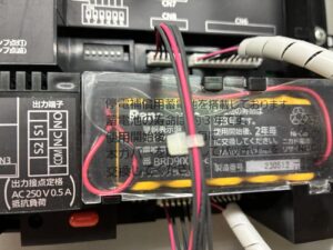 岐阜市の病院でスプリネクス警報表示盤のバッテリー点検を行う女性消防設備士