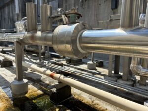 屋上ボイラー給湯配管からの水漏れを確認する漏水調査の様子