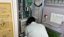 介護施設の火災受信機内部を点検する消防設備士｜春日井市の消防設備点検