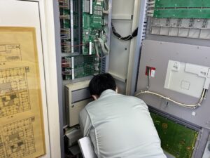 介護施設の火災受信機内部を点検する消防設備士｜春日井市の消防設備点検