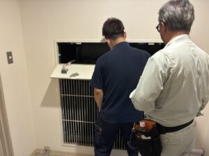 排煙口の開放状態を確認し、建築設備定期検査を実施している様子