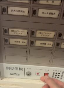 岐阜市の介護施設で受信機の復旧操作を行う女性消防設備士