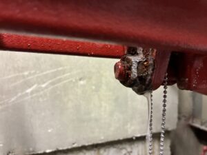 スプリンクラー設備の漏水箇所を点検・確認する消防設備士