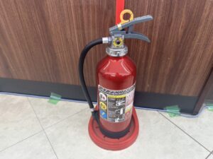期限切れ消火器の新品交換作業を行う消防設備業者