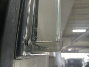 工場内の防水型誘導灯に発生した内部浸水の点検状況