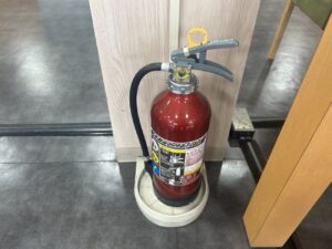 自動車販売店に設置された消火器の交換作業を行う大井ぐるーぷ